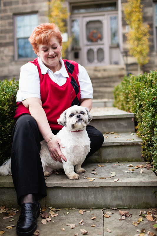 Dog and owner on steps of historic house in Milton's Mill Pond Park.