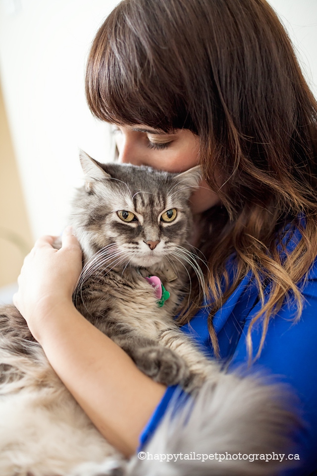 A woman tenderly cuddles her pet cat photo.
