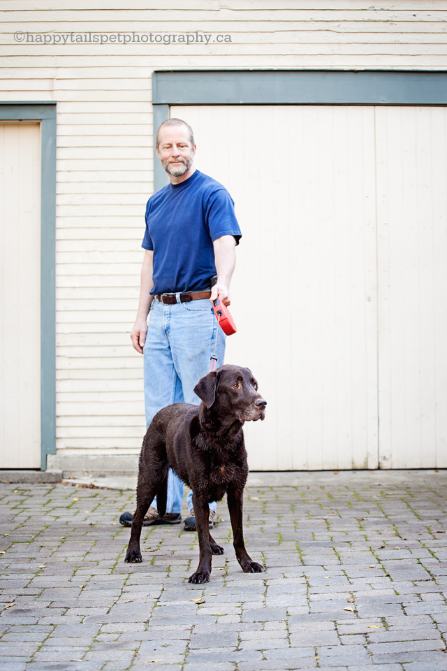 Owner holds his labrador retriever on a leash.