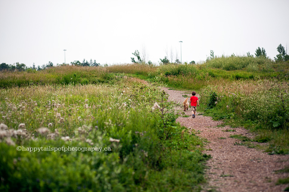 Boy and dog play and run up a hill in Bronte Provincial Park, Burlington.