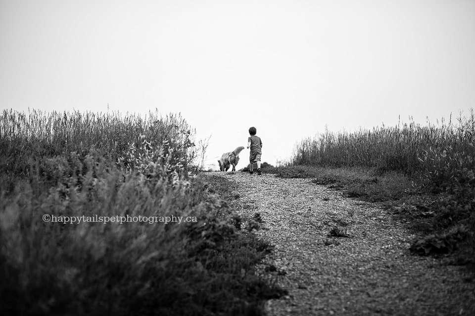 Documentary pet photography of dog and boy on hill, black and white, photo.