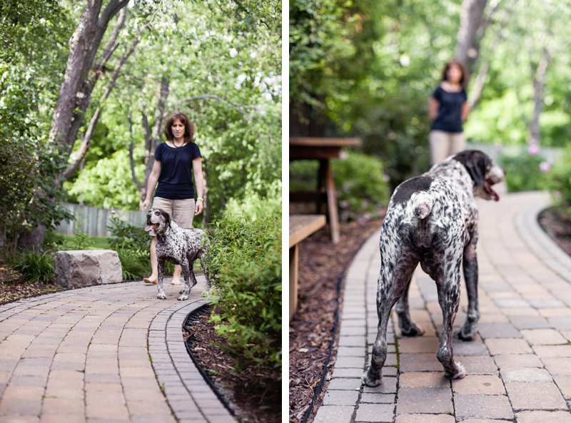 Coonhound dog and woman owner in yard with green landscaping, photo.