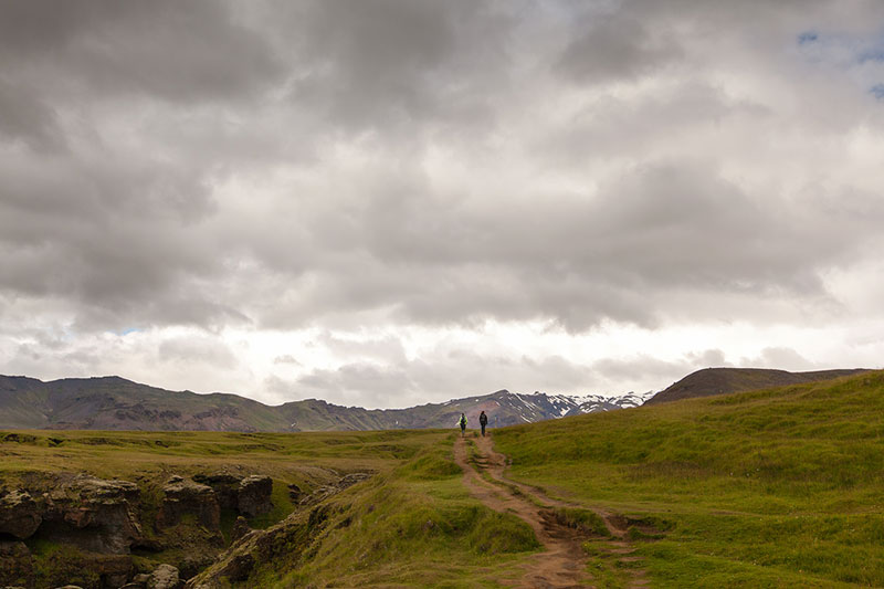 Hiking along Waterfall Way above Skogafoss waterfall in Iceland.