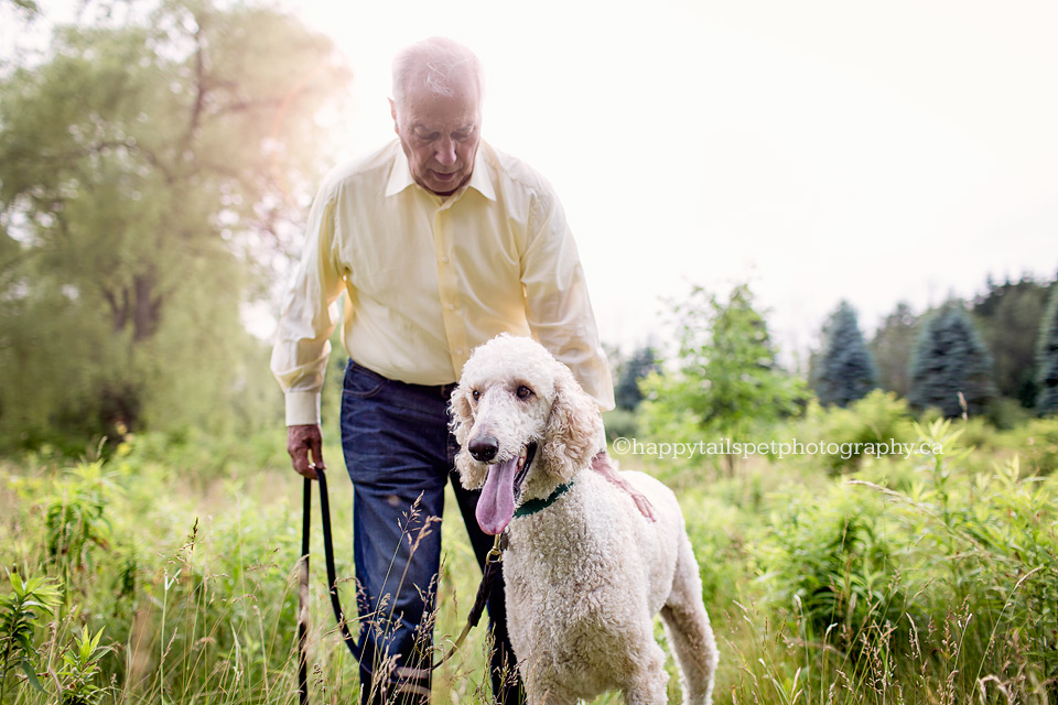 Photo of senior and his poodle dog in natural setting.