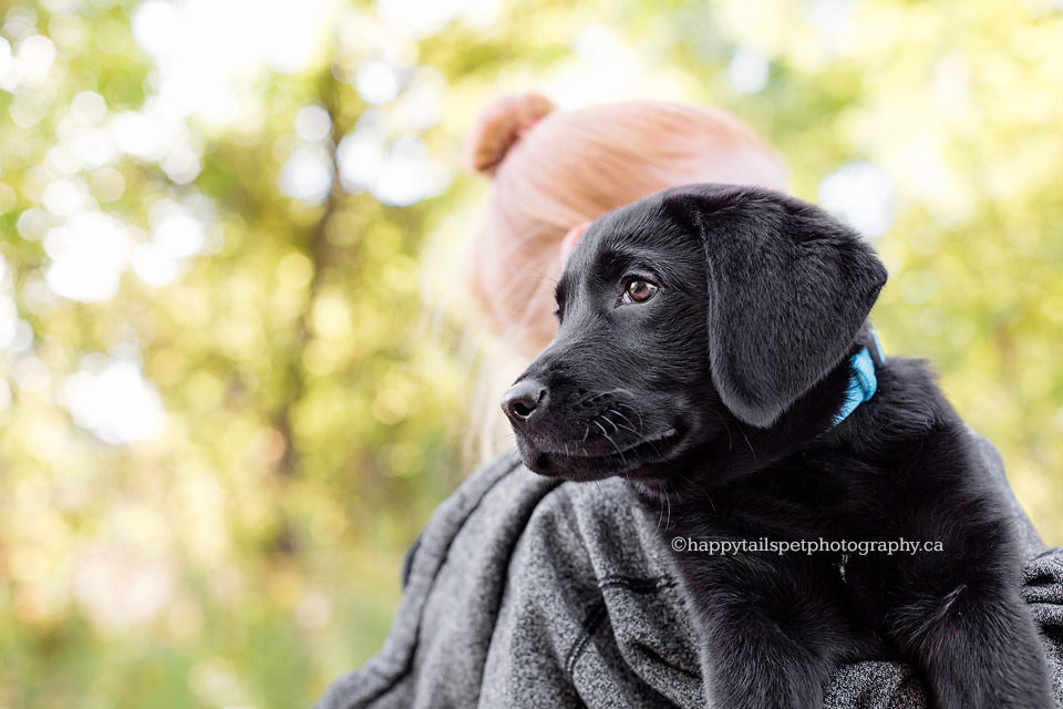 Girl with read hair holds her new puppy.