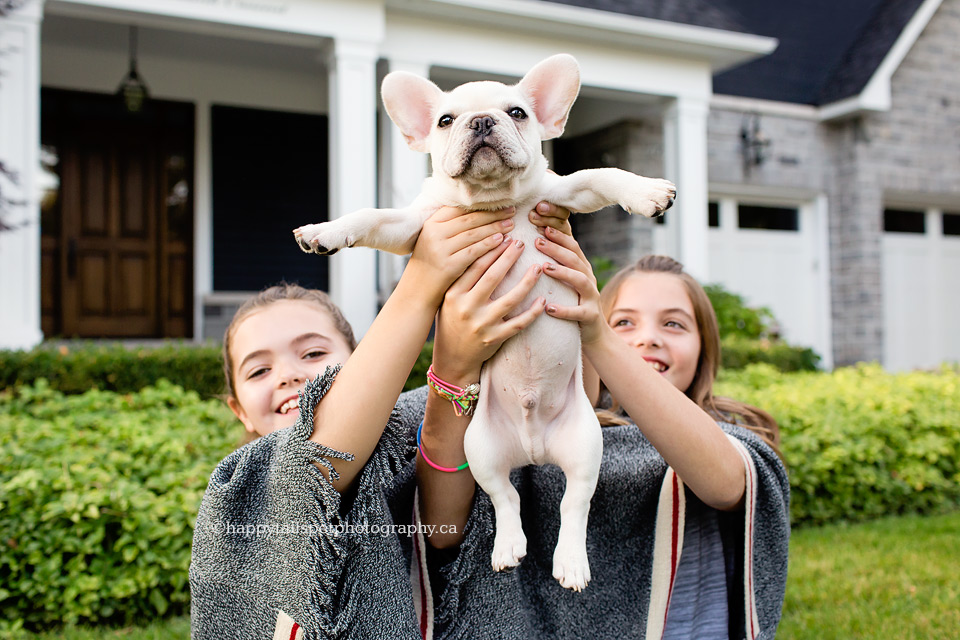 Two girls welcome a new puppy at upscale Oakville home.