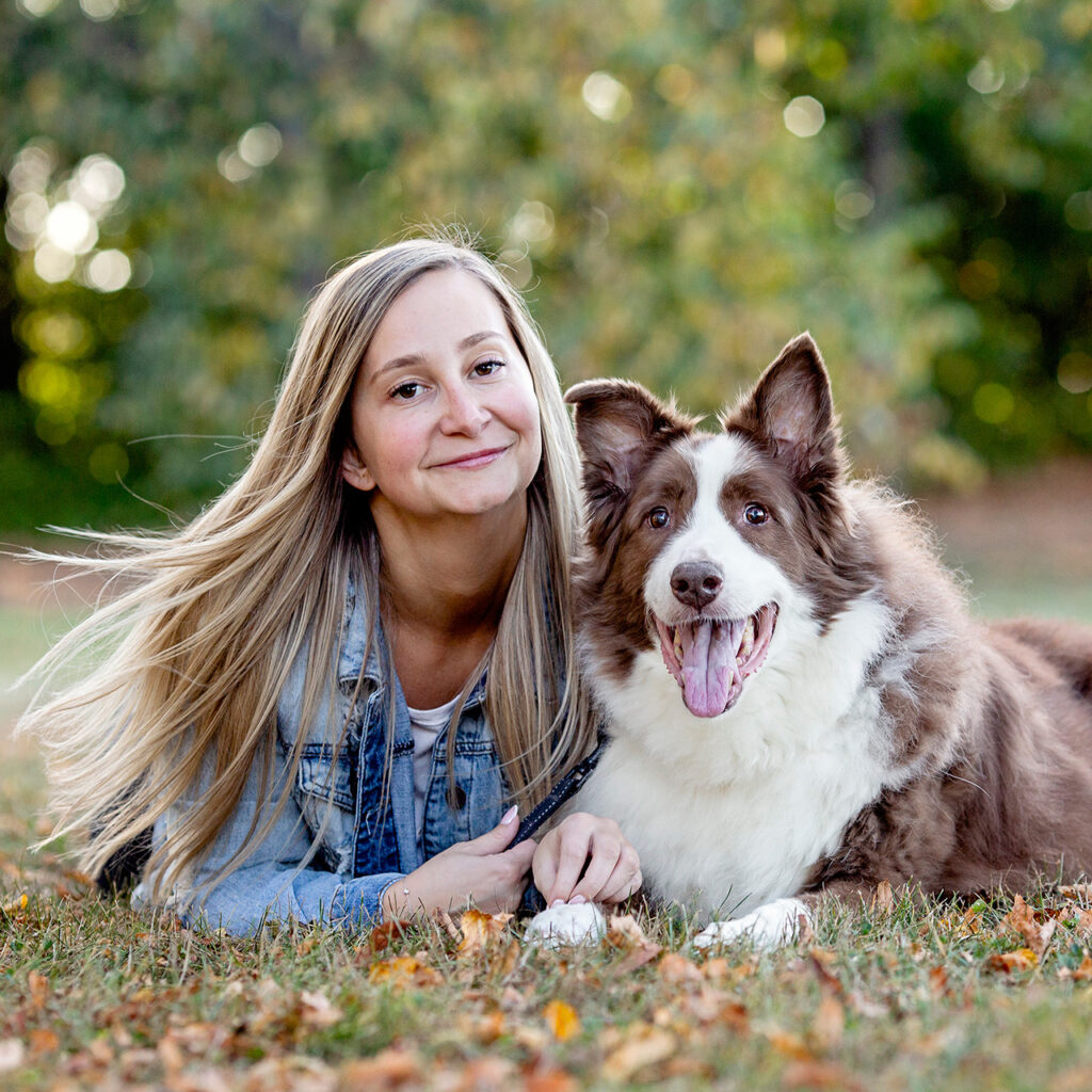 Outdoor pet photography of young woman with brown and white dog.