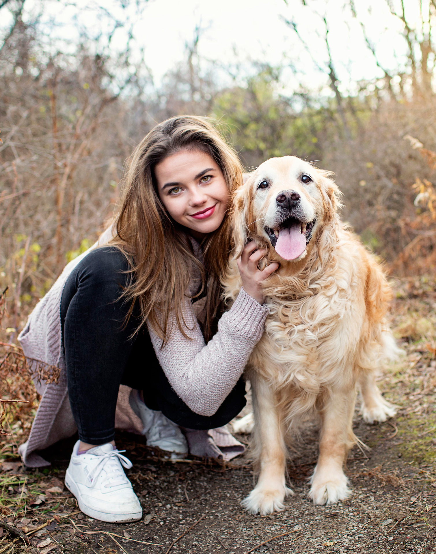 Pretty girl and senior golden retriever dog posing on trail at Kerncliff Park in Burlington.